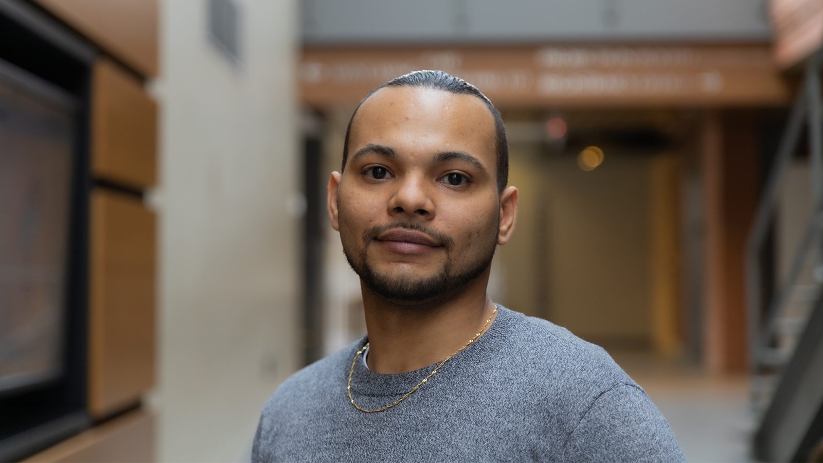 student eli rose stands in the innis college atrium