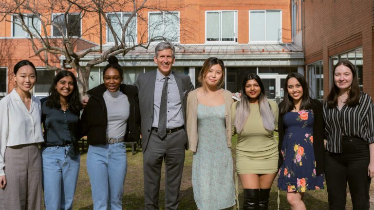 A group of upper-year students poses with Principal Keil on the Innis Green