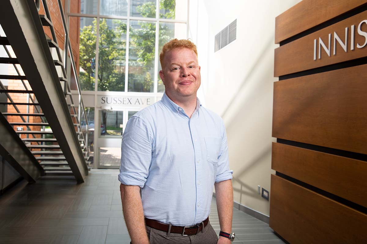david roberts stands in the east atrium of innis college