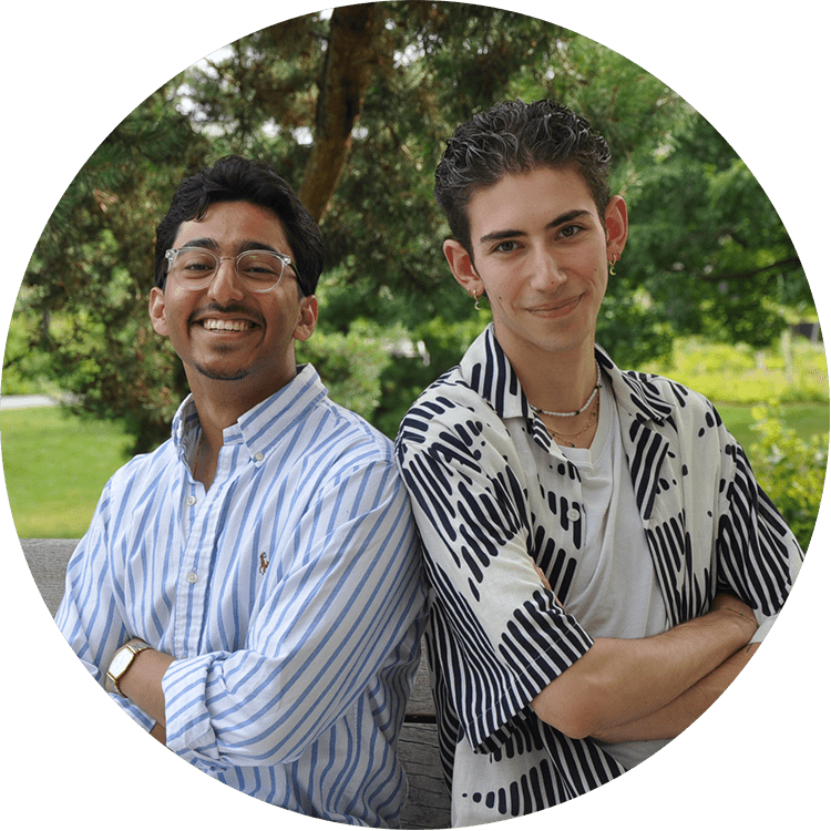 photo of Aarush and Landon sitting back-to-back in a park