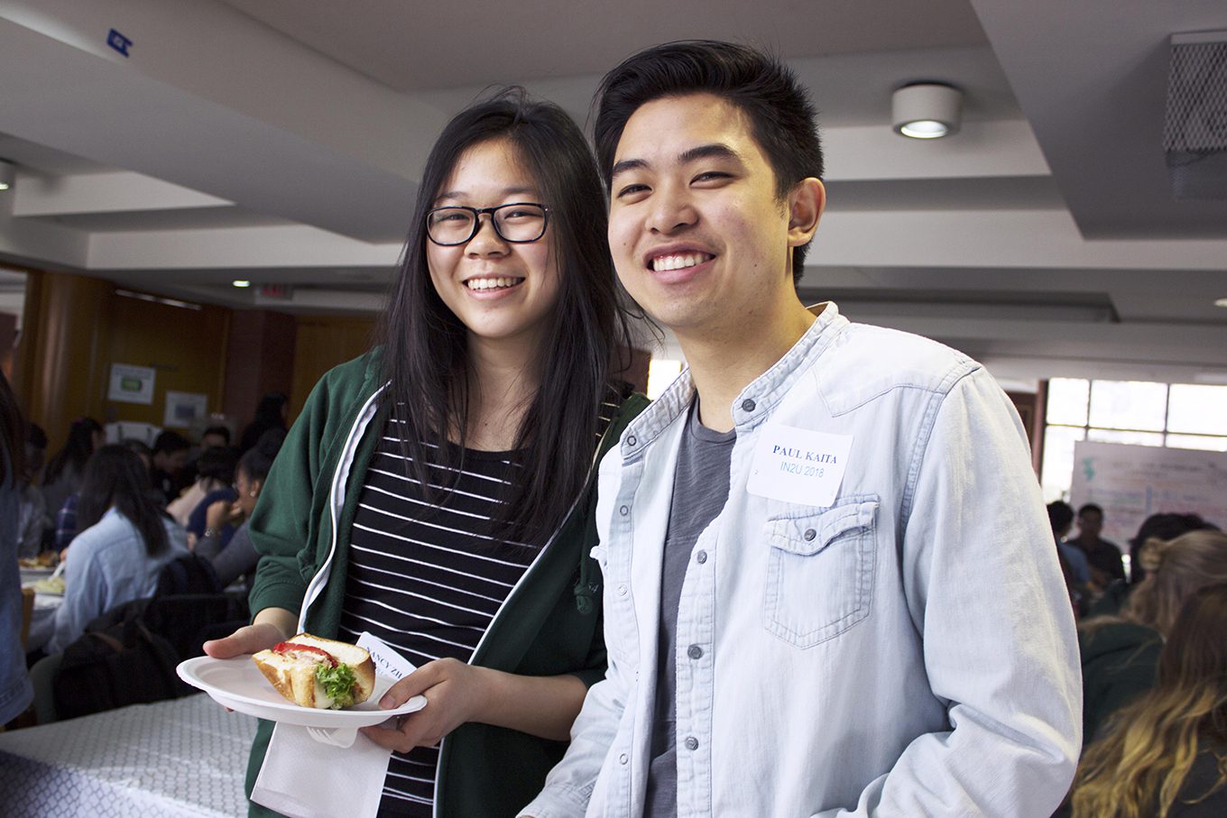two students smiling amid a residence event with food